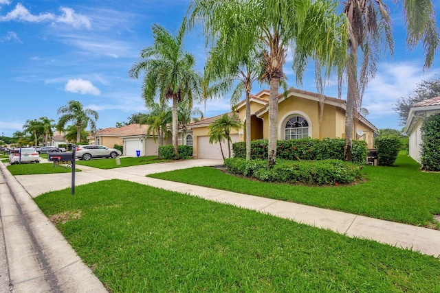 mediterranean / spanish-style home featuring a front lawn and a garage