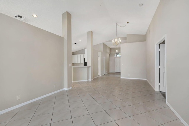 spare room featuring light tile patterned floors, high vaulted ceiling, and an inviting chandelier