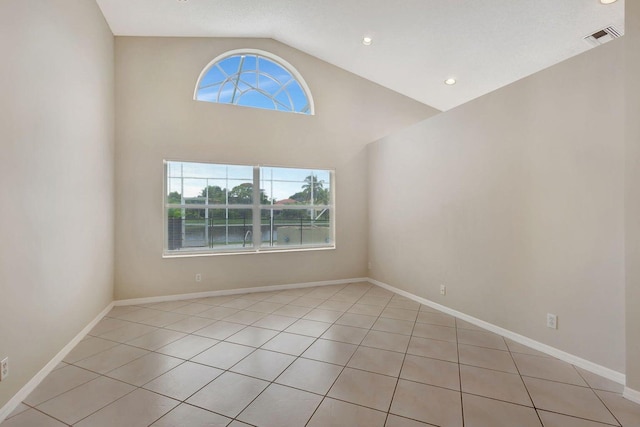 unfurnished room featuring light tile patterned flooring and high vaulted ceiling