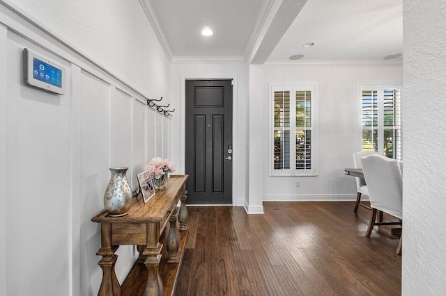 foyer with dark hardwood / wood-style floors, ornamental molding, and a textured ceiling