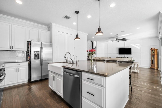 kitchen featuring white cabinets, stainless steel appliances, a kitchen island with sink, and ceiling fan