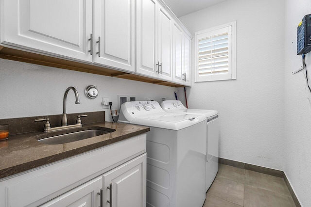 clothes washing area featuring washer and clothes dryer, cabinets, and sink