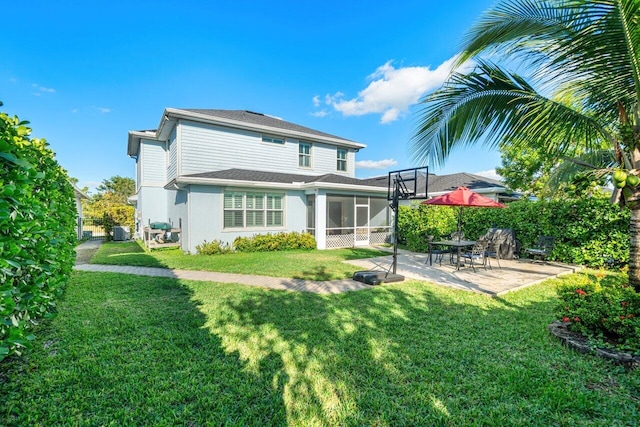 back of property with a sunroom, a yard, and a patio