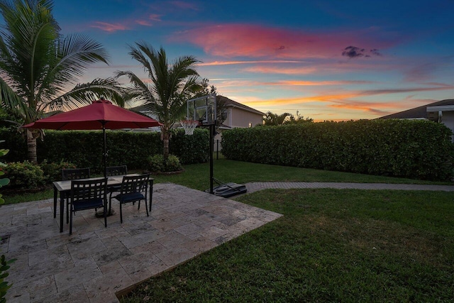 yard at dusk featuring a patio