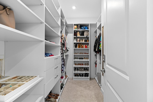 walk in closet featuring light colored carpet