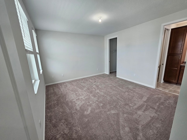 carpeted empty room with a textured ceiling