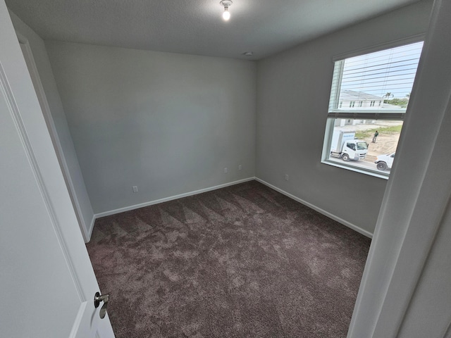 empty room with dark colored carpet