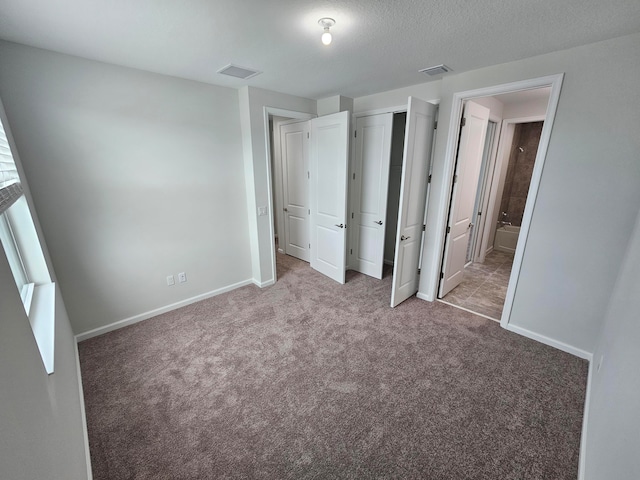 unfurnished bedroom featuring light colored carpet and ensuite bath