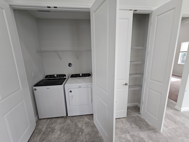 laundry room with washer and dryer and light tile patterned floors