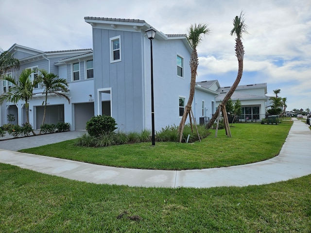 view of home's exterior with a lawn, central AC unit, and a garage