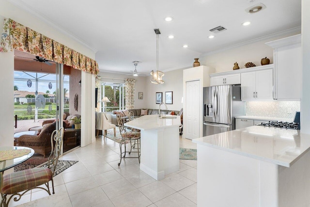 kitchen featuring light tile patterned flooring, stainless steel refrigerator with ice dispenser, hanging light fixtures, a kitchen island, and white cabinetry