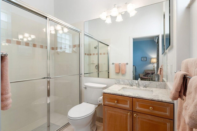 bathroom with vanity, toilet, and a shower with door