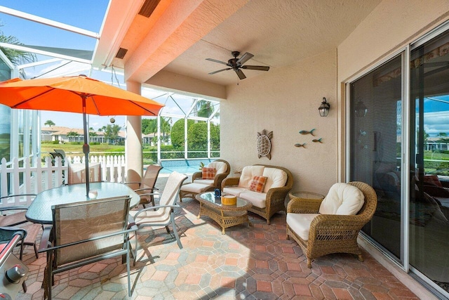 view of patio featuring an outdoor living space, glass enclosure, and ceiling fan