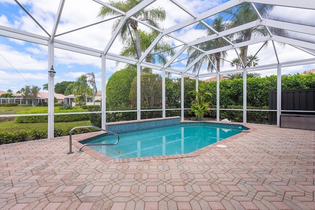 view of pool featuring glass enclosure and a patio