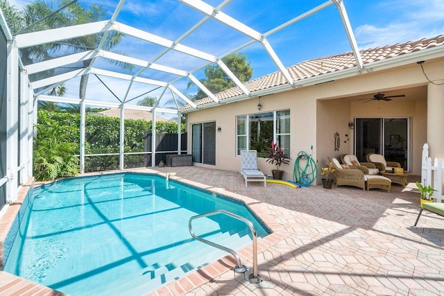 view of pool featuring a lanai, ceiling fan, a patio, and an outdoor living space