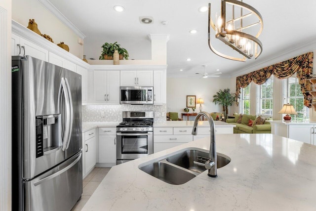 kitchen with white cabinets, sink, crown molding, light stone counters, and stainless steel appliances