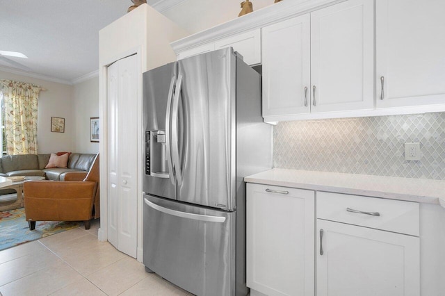 kitchen featuring white cabinetry, stainless steel fridge with ice dispenser, crown molding, and tasteful backsplash