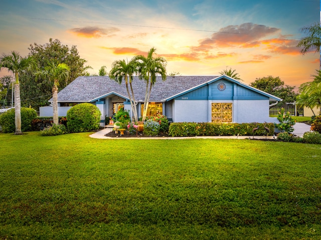 ranch-style home featuring a lawn