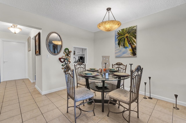 tiled dining area with a textured ceiling