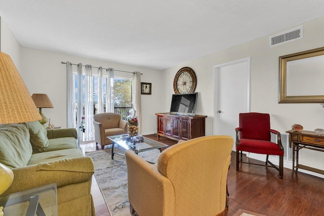 living room with hardwood / wood-style floors and a textured ceiling