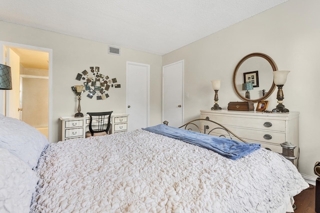 bedroom featuring a textured ceiling and dark hardwood / wood-style flooring