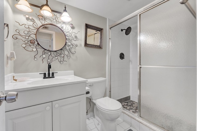 bathroom featuring toilet, vanity, tile patterned floors, and a shower with shower door