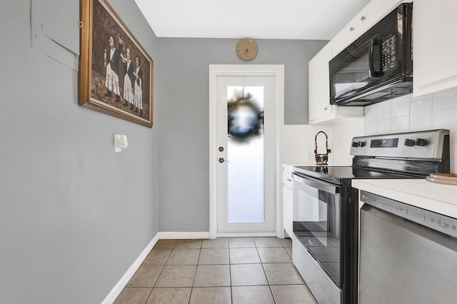 kitchen with white cabinets, stainless steel appliances, tasteful backsplash, and light tile patterned flooring