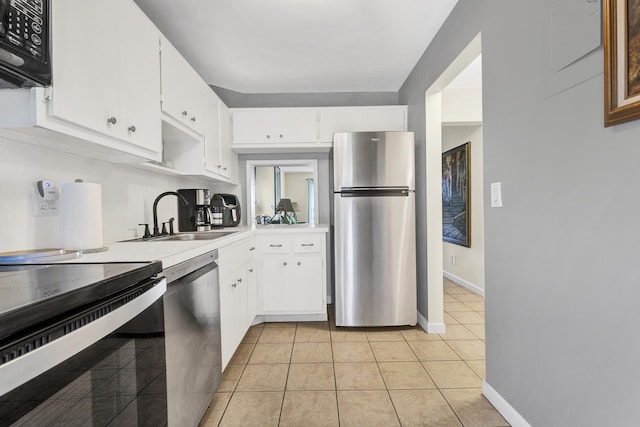 kitchen with sink, white cabinets, black appliances, and light tile patterned floors