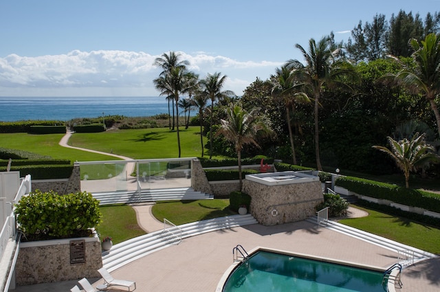 community pool featuring a patio, a water view, and fence