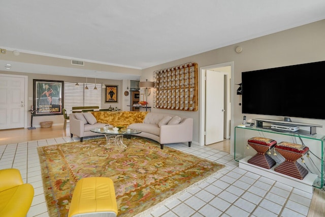 living area with light tile patterned floors, baseboards, and visible vents