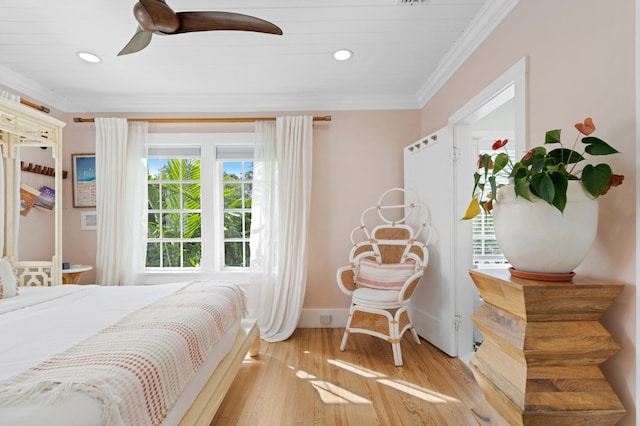 bedroom featuring light hardwood / wood-style flooring, ceiling fan, and ornamental molding