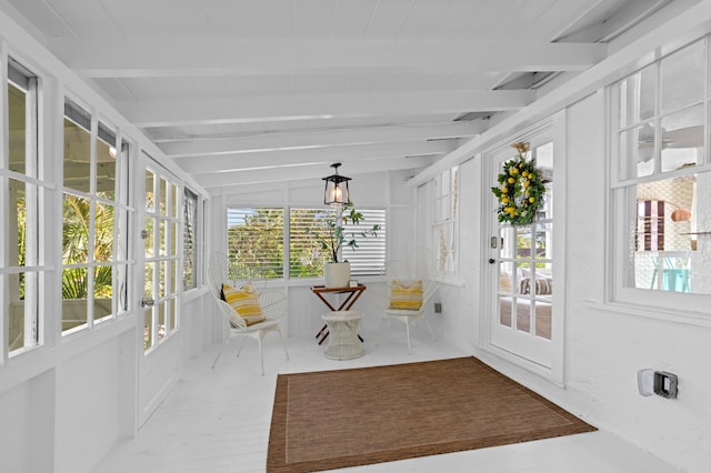 unfurnished sunroom featuring vaulted ceiling with beams and plenty of natural light