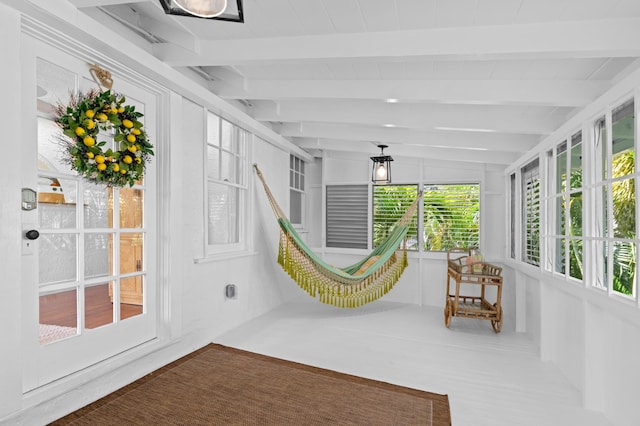 sunroom featuring vaulted ceiling with beams