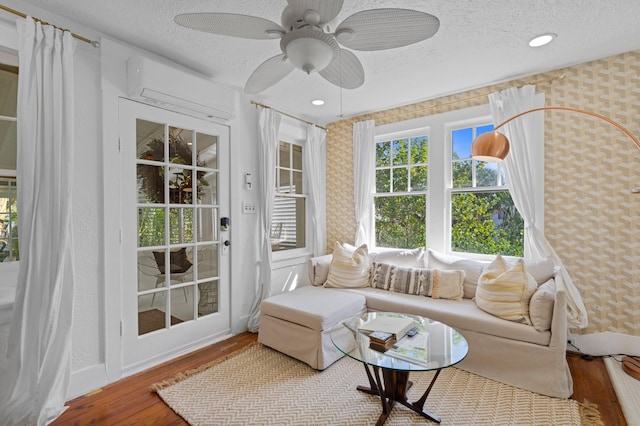 sunroom featuring an AC wall unit and ceiling fan