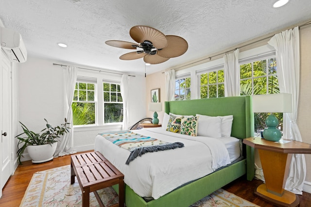 bedroom featuring a textured ceiling, ceiling fan, dark wood-type flooring, and multiple windows