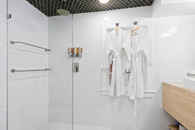 bathroom featuring vanity, tile walls, and a shower with shower door