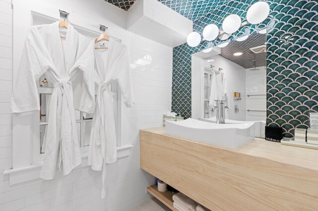 bathroom with tile patterned floors, vanity, and tile walls