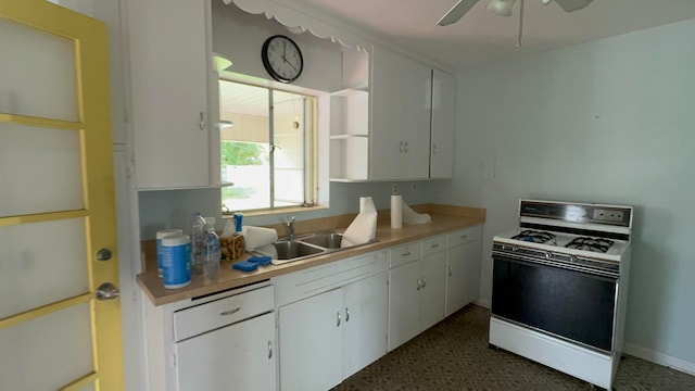 kitchen featuring white range oven, ceiling fan, sink, and white cabinets