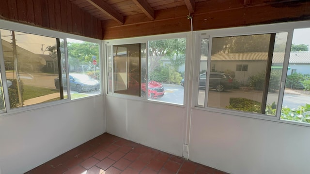 unfurnished sunroom featuring beamed ceiling and wooden ceiling