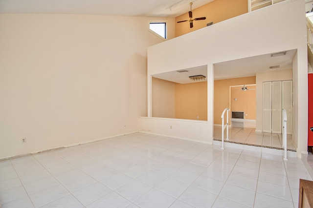 tiled empty room featuring a towering ceiling