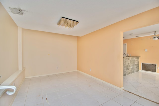 empty room featuring ceiling fan and light tile patterned floors