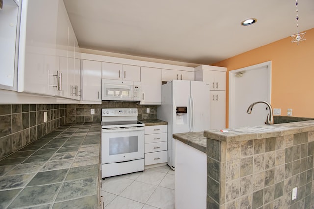 kitchen with decorative backsplash, white cabinets, and white appliances