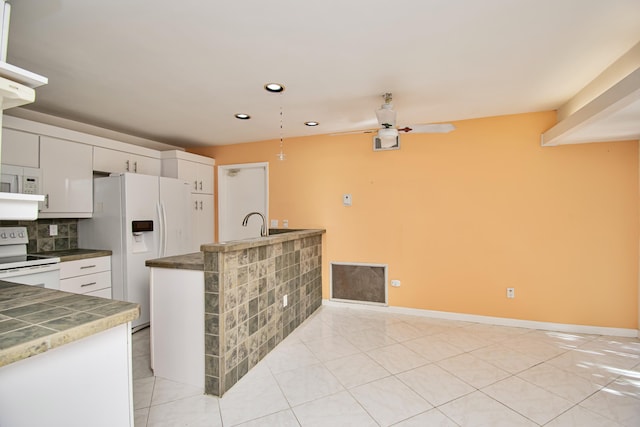 kitchen with light tile patterned floors, ceiling fan, decorative backsplash, white appliances, and white cabinets