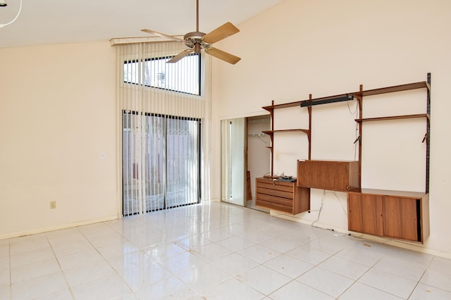 unfurnished living room with ceiling fan, light tile patterned floors, and high vaulted ceiling