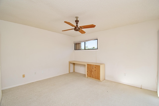 carpeted empty room featuring a textured ceiling and ceiling fan