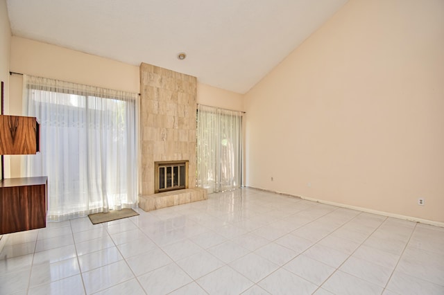 unfurnished living room with light tile patterned floors, lofted ceiling, and a tile fireplace