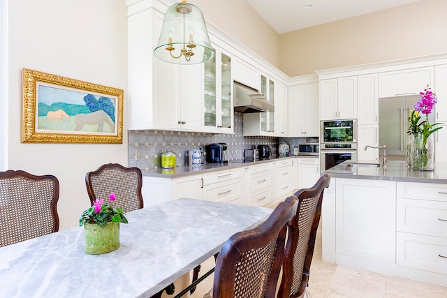 kitchen featuring white cabinetry, sink, wall chimney range hood, tasteful backsplash, and appliances with stainless steel finishes