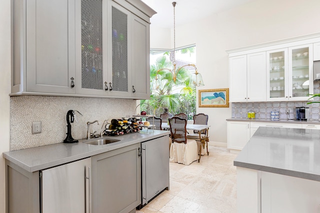 kitchen with stainless steel fridge, decorative backsplash, sink, and pendant lighting