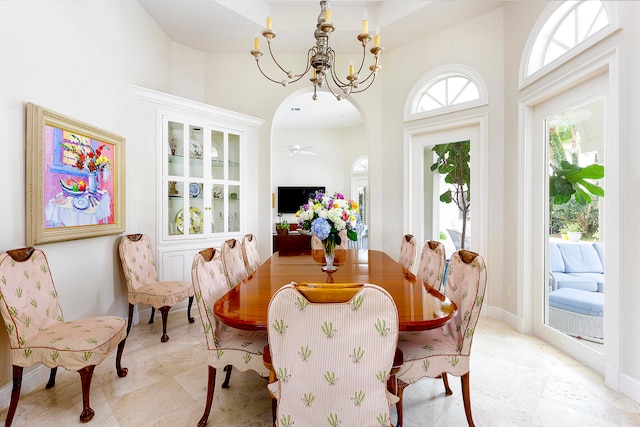 dining area featuring ceiling fan with notable chandelier