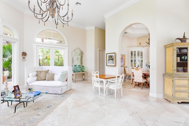 living room with a towering ceiling, crown molding, and an inviting chandelier